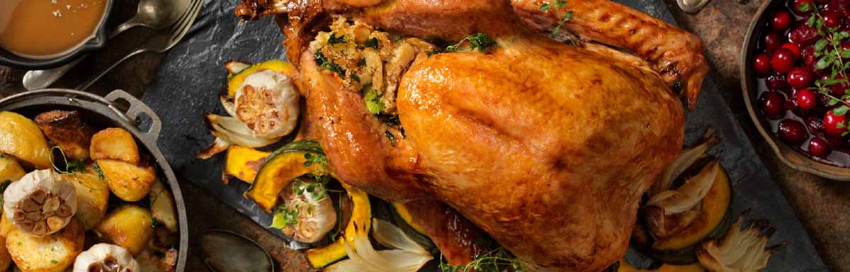 Un jamón de pavo acompañado de diferentes guarniciones navideñas. Un jamón de pavo acompañado de diferentes guarniciones navideñas.