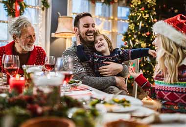  Una familia disfrutando de una cena con guarniciones navideñas. 