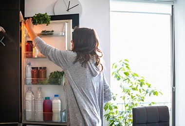 Mujer guardando alimentos en refrigerador, verduras que se pueden congelar