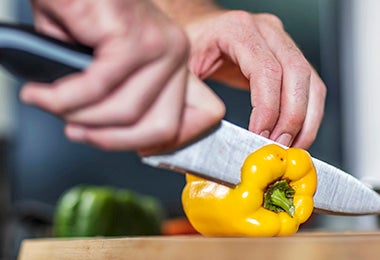 Pimentón amarillo siendo cortado para rellenar en un asado vegetariano