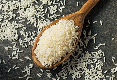 Arroz blanco sobre una cuchara de madera