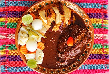 Un plato de mole con pollo y verduras.