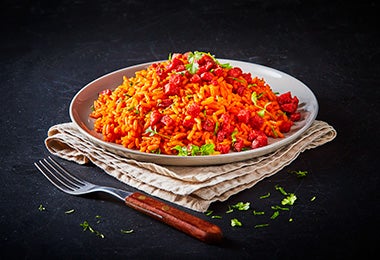 Arroz rojo servido con chorizo y especias.