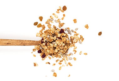 Cuchara con mezcla de ingredientes para hacer granola 