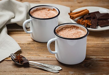 Dos tazas de chocolate caliente con canela 