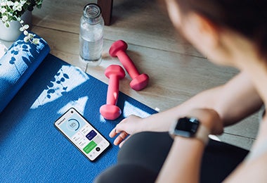 Mujer con mancuernas y mat de entrenamiento qué comer después de hacer ejercicio