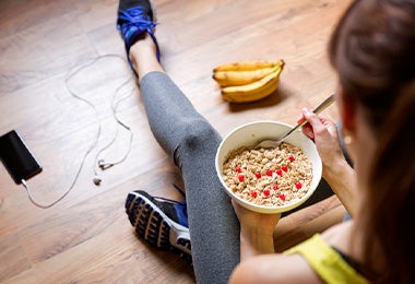 Mujer comiendo avena y cambur antes de hacer ejercicio 