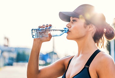 Mujer tomando agua fundamental antes de hacer ejercicio 
