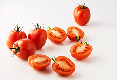 Grupo de tomates, algunos cortados por la mitad, para usar en una salsa pomodoro.