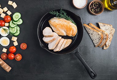 Pechuga de pollo con verduras, preparada en un sartén de hierro.