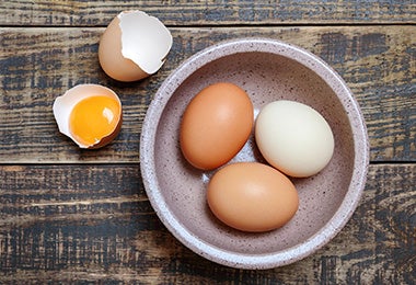 Tazón con huevos separando la yema de la clara para preparar una masa para waffles