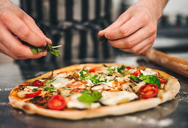 Una pizza italiana tradicional con verduras y queso, un atractivo del turismo gastronómico.