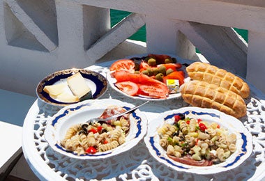 Una mesa con dos platos servidos y con vista al mar, una posibilidad del turismo gastronómico.