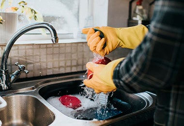 Un hombre lavando utensilios de cocina