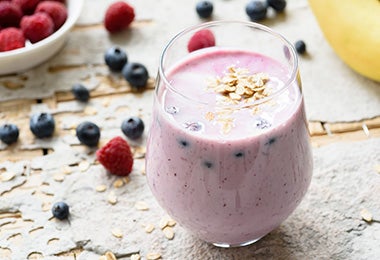 Vaso con batido de frutos rojos para beber antes de hacer ejercicio 