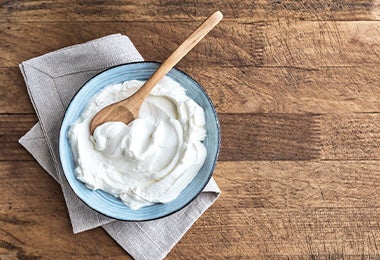 Yogurt con cuchara de madera, uno de los sustitutos del huevo