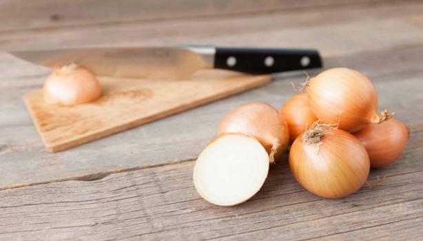 Cebollas sobre una mesa, listas para cortar en julianas o rodajas