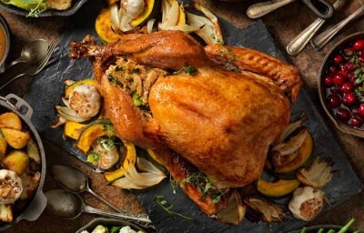 Un jamón de pavo acompañado de diferentes guarniciones navideñas. 