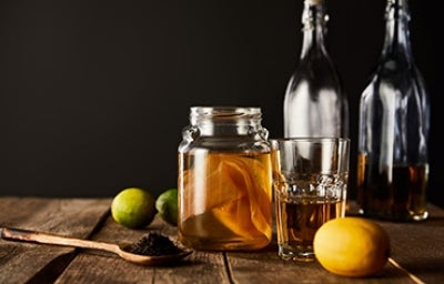 Frutas cítricas, botellas y vasos con kombucha Frutas cítricas, botellas y vasos con kombucha