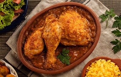 Plato de receta de pollo en salsa con ensalada y arroz Plato de receta de pollo en salsa con ensalada y arroz