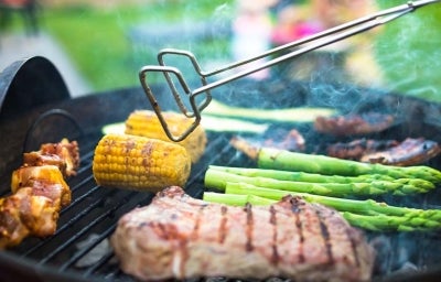 Asado de carne y vegetales, con pinzas para darles vuelta, un utensilio muy importante.