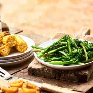 Mazorcas y espárragos sobre una mesa de madera en un asado vegetariano