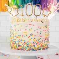 Torta de cumpleaños con chispas de colores y vela 